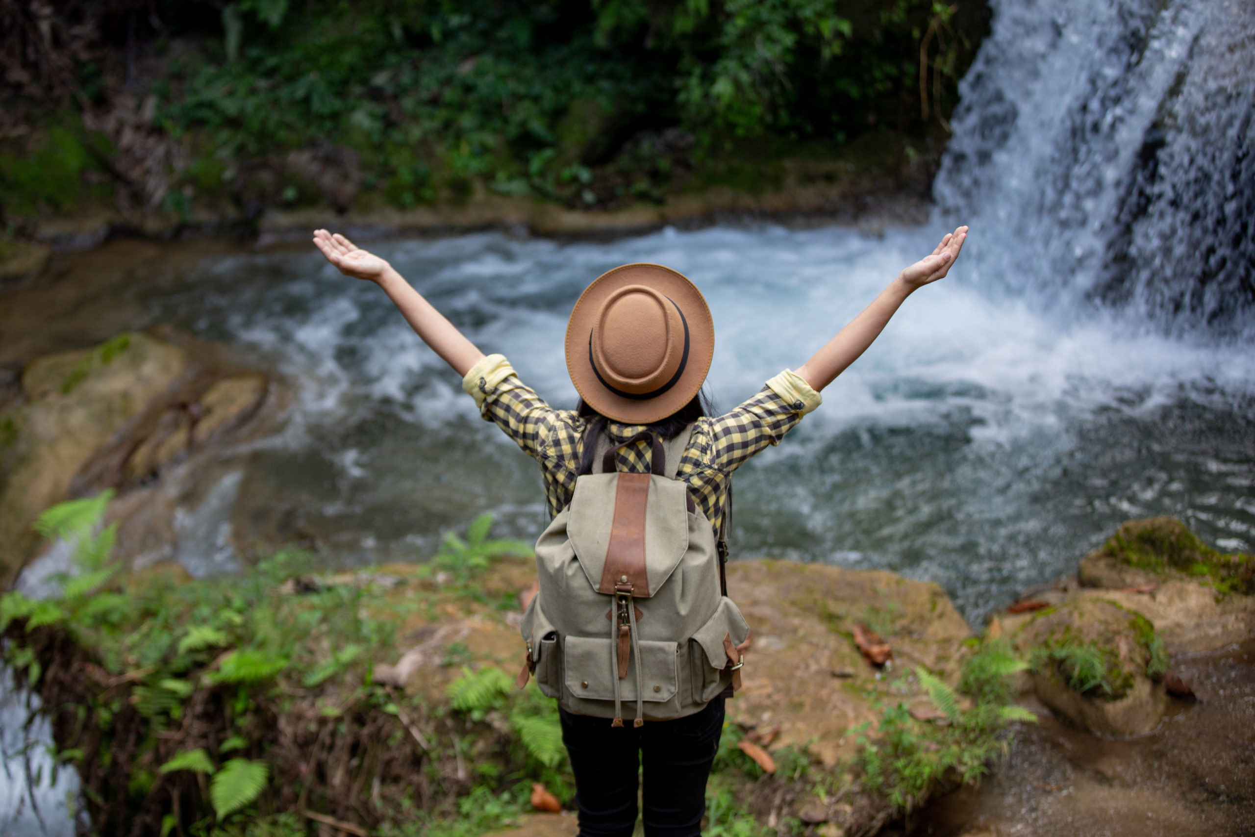 Female tourists are happy and refreshed at the waterfall.